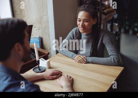 Jeune femme assez élégante à ce jour avec un beau homme dans le café. Belle conversation. Rencontre avec un ami. Banque D'Images