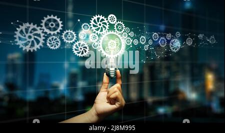 Homme d'affaires tenant une ampoule avec un cog à l'intérieur. Idée d'entreprise bulbe Gear icône connexion réseau avec Creative et inspiration. Innovation, leader Banque D'Images