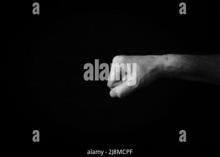 Image spectaculaire en noir et blanc de Fist emoji, face à gauche, isolée sur fond noir Banque D'Images
