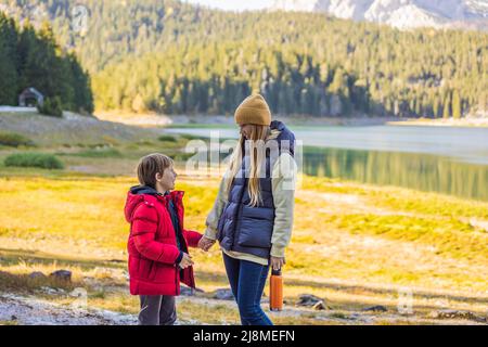 Les touristes de maman et de fils en arrière-plan de la vue panoramique du matin sur le lac Noir Crno Jezero. Scène estivale calme du parc de Durmitor Nacionalni, Zabljak Banque D'Images