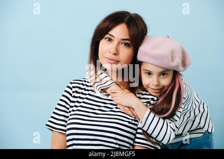 Maman et sa fille intermédiaire en béret français se posant ensemble pour une photo Banque D'Images