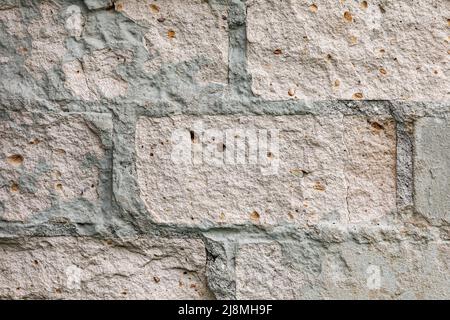 Vieux mur en brique de plâtre gris avec stuc ébréché. Grunge le mur de briques blanches avec un fond de surface endommagé Banque D'Images