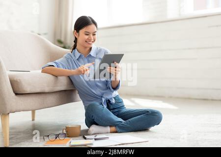 Une dame chinoise qui profite de la dernière application mobile sur tablette Banque D'Images