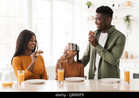 Famille afro-américaine manger Pie déjeuner dans la cuisine Banque D'Images