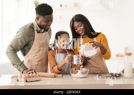 Happy Black Family tamisage de farine faire de la pâte dans la cuisine Banque D'Images