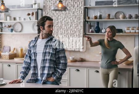 Malheureux triste caucasien millénaire mâle avec le chaume écoute émotif jurant femme blonde, dame hurle Banque D'Images