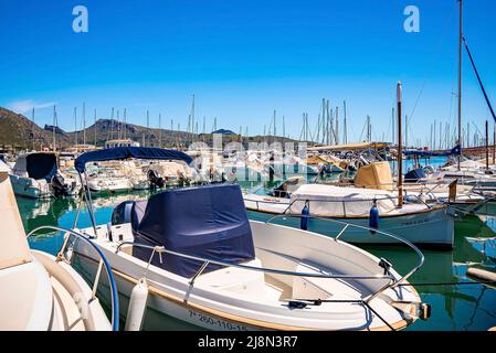 Bateaux à moteur et voiliers ancrés au bord de la mer au port, dans un ciel bleu clair Banque D'Images