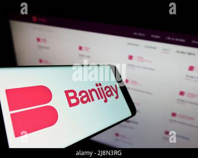 Smartphone avec logo de la société française de divertissement Banijay Group sur écran en face du site Web d'affaires. Mise au point au centre-gauche de l'écran du téléphone. Banque D'Images