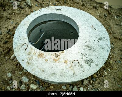 Joints de puits en béton creusés avec un couvercle en béton. Plomberie et égouts. Banque D'Images