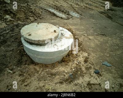 Joints de puits en béton creusés avec un couvercle en béton. Plomberie et égouts. Banque D'Images