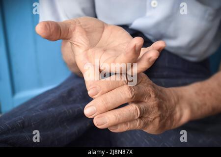 Renforcement de l'exercice pour la santé des doigts de patients asiatiques âgés de sexe masculin avec spasme musculaire. Banque D'Images