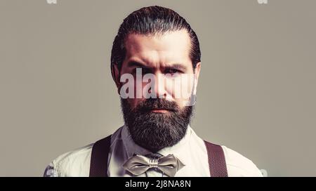 Portrait de beau barbu homme en chemise blanche et noeud papillon, bretelles. Gros plan d'un homme son noeud papillon. Homme de barbe en noeud papillon et bretelles. Homme Banque D'Images