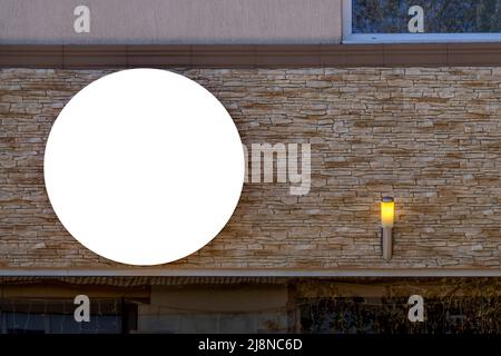 Maquette. Vider les panneaux blancs ronds des magasins, des magasins, des restaurants et des bureaux sur le mur du bâtiment dans la ville Banque D'Images