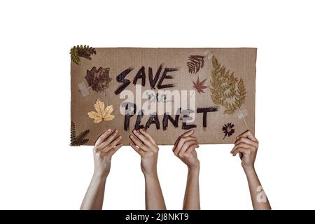 Carton avec le message "Save the Planet", les feuilles et les fleurs sont à la main de deux activistes Banque D'Images