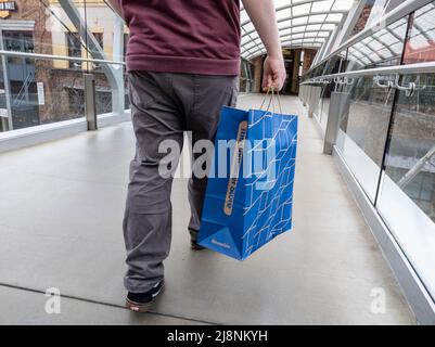 Bellevue, WA USA - vers avril 2022 : vue à angle bas d'un homme qui marche avec un sac depuis le Container Store tout en flânant dans le Bellevue Mall Banque D'Images