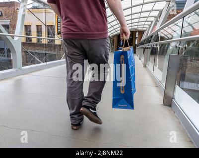 Bellevue, WA USA - vers avril 2022 : vue à angle bas d'un homme qui marche avec un sac depuis le Container Store tout en flânant dans le Bellevue Mall Banque D'Images