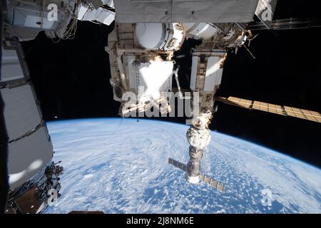 Le 16 mai 2022 - atmosphère terrestre - la Lune, avec l'ombre de la Terre qui s'y traverse pendant une éclipse lunaire et qui est représentée juste au-dessus de l'horizon, est naine entre les composantes de la Station spatiale internationale américaine et russe. À gauche, se trouve le cargo spatial américain Northrop Grumman Cygnus, avec le module Rassvet en Russie au centre, et un trio d'éléments de station russe attachés l'un à l'autre, y compris (de bas en haut) le navire à équipage Soyuz MS-21, le module d'amarrage Prithal et le module de laboratoire polyvalent Nauka. La station était orbitante à 273 milles au-dessus du sud de l'océan Indien au large de la côte de Banque D'Images