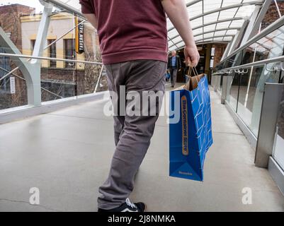 Bellevue, WA USA - vers avril 2022 : vue à angle bas d'un homme qui marche avec un sac depuis le Container Store tout en flânant dans le Bellevue Mall Banque D'Images