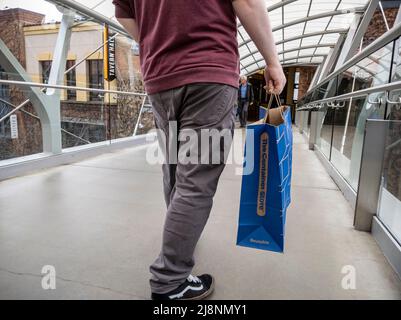 Bellevue, WA USA - vers avril 2022 : vue à angle bas d'un homme qui marche avec un sac depuis le Container Store tout en flânant dans le Bellevue Mall Banque D'Images