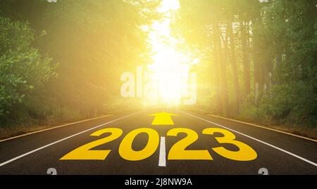 Le mot 2023 écrit sur la route forestière. Concept pour la nouvelle année 2023. Itinéraire vers la nouvelle année indiqué par la flèche. Banque D'Images