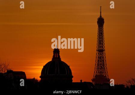 Le soleil se couche derrière la Tour Eiffel et le dôme de l'Institut de France, vu du quai de la Mégisserie, près de la place du Châtelet. Banque D'Images