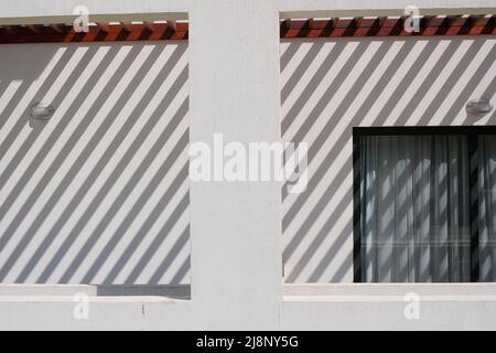 lignes géométriques sur un mur et une fenêtre blancs. concept de motif architectural abstrait, lumière et ombres Banque D'Images