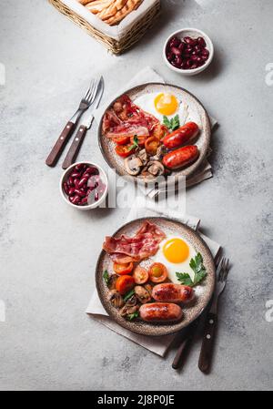 Petit-déjeuner anglais sur des assiettes grises sur fond blanc Banque D'Images