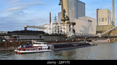 Mannheim, Allemagne - avril 2022 : grue déchargeant du charbon d'une barge industrielle dans une centrale électrique sur le Rhin. L'usine est exploitée par CKM. Banque D'Images