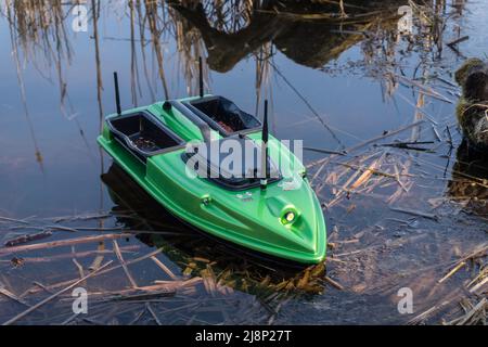 Bateau à appâts sur l'eau. Mangeoire de pêche verte avec télécommande sans fil, bateau de recherche de poissons. Banque D'Images