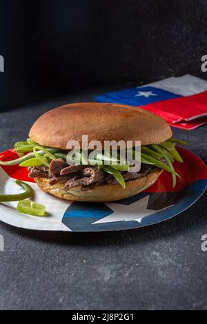 Hamburger chilien latino-américain Chacarero avec tranches de bœuf de qualité supérieure et haricots verts sur fond noir. Banque D'Images