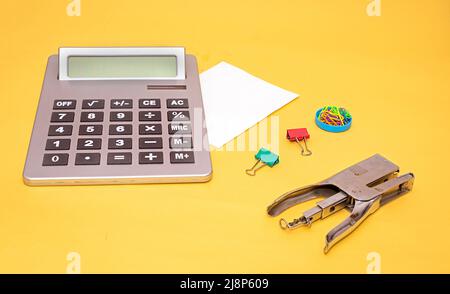 Calculatrice électronique moderne avec agrafeuse en métal et trombones papeterie de bureau Banque D'Images
