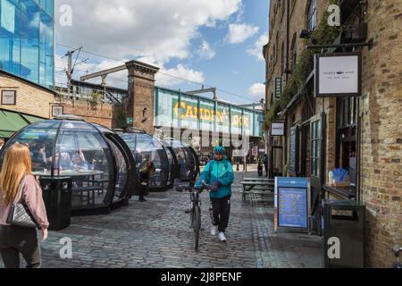 Les clients peuvent manger leur repas dans les gousses du marché de Camden. Le célèbre pont de Camden est visible de l'autre côté de la rue. Banque D'Images