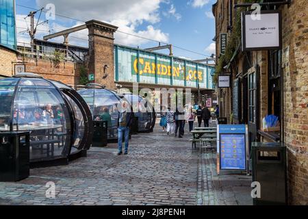 Les clients peuvent manger leur repas dans les gousses du marché de Camden. Le célèbre pont de Camden est visible de l'autre côté de la rue. Banque D'Images