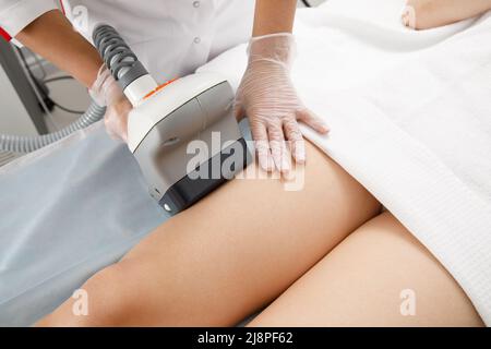 Une femme subit une procédure anti-cellulite dans une clinique de cosmétologie. Banque D'Images