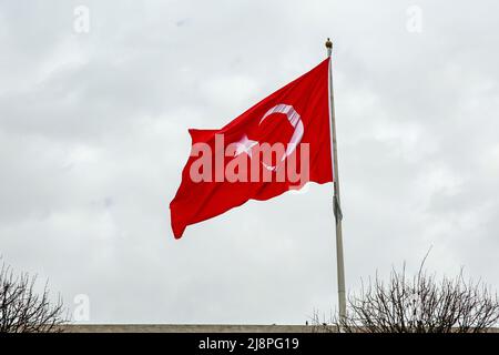 Drapeau turc agité contre un ciel nuageux Banque D'Images