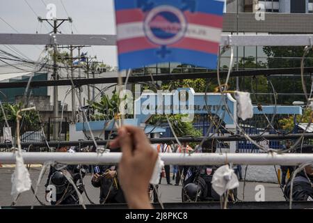 San Salvador, El Salvador. 17th mai 2022. Un démonstrateur porte un drapeau de fierté transgenre à côté d'une clôture barbelée lors d'une manifestation pour les droits des membres de la communauté LGBT, y compris une loi d'identité pour les personnes transgenres. La Journée internationale contre l'homophobie, la biphobie et la transphobie est commémorée chaque 17 mai afin de sensibiliser la population aux violations des droits LGBT, y compris les crimes haineux et les meurtres commis contre la communauté. Crédit : SOPA Images Limited/Alamy Live News Banque D'Images