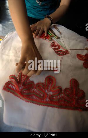 Une femme triant des motifs décoratifs sur le textile à l'aide d'un outil traditionnel à Sawahlunto, Sumatra Ouest, Indonésie. Banque D'Images