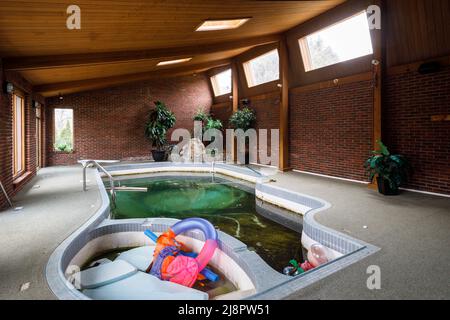 Une piscine intérieure très sale à l'intérieur d'une maison abandonnée. Cette maison a depuis été démolie. Banque D'Images