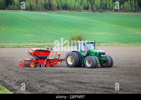 Agriculteur travaillant avec le tracteur John Deere 6820 et le semoir Väderstad Biodrill dans le champ un jour de printemps. Salo, Finlande. 15 mai 2021. Banque D'Images