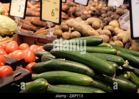 Légumes du marché alimentaire avec étiquette de prix. Divers concombres mûrs frais, tomates, pommes de terre et autres produits agricoles en vente sur le marché Banque D'Images