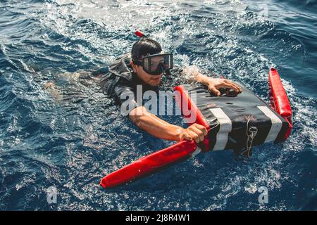 Golfe d'Oman. 8th mai 2022. Technicien en systèmes de turbine à gaz (mécanique) 3rd classe Christian Vitorvo simule un sauvetage lors d'opérations de petit bateau à bord du destroyer à missiles guidés USS Momsen (DDG 92) dans le golfe d'Oman, mai 8. Momsen est déployé dans la zone d'opérations de la flotte américaine 5th afin d'assurer la sécurité et la stabilité maritimes dans la région du Moyen-Orient. Credit: U.S. Navy/ZUMA Press Wire Service/ZUMAPRESS.com/Alamy Live News Banque D'Images