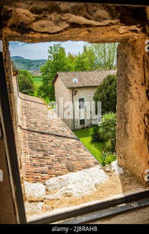 1 mai 2022 - Priverno, Latina, Latium, Italie - Abbaye de Fossanova. Le jardin de la cour, vu du haut d'une petite fenêtre du monastère. Le toit avec Banque D'Images