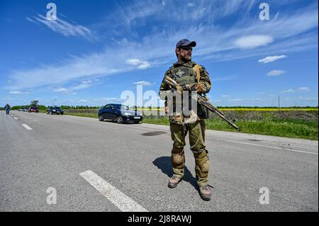 Un soldat ukrainien armé se trouve au milieu d'une route, région de Zaporizhjhia, sud-est de l'Ukraine, le 17 mai 2022. Photo de Dmytro Smolyenko/Ukrinform/ABACAPRESS.COM Banque D'Images