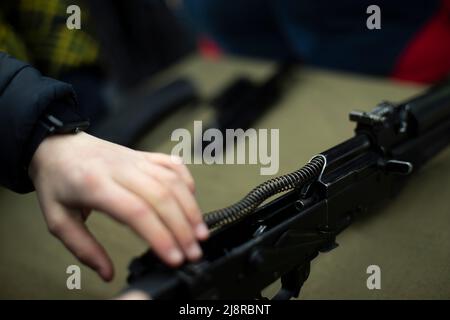 Assemblage du fusil d'assaut AK 47. Armes à feu fusil d'assaut Kalashnikov. Les gens ramassant le pistolet factice. Entraînement militaire. Banque D'Images