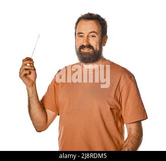 homme barbu effectuant un test d'antigène avec expression désagréable. sur fond blanc isolé pour la publicité. Mal à l'aise lors du test. Banque D'Images