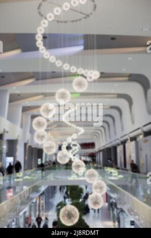 Un beau long lustre de boules lumineuses disposées dans une spirale de petits à grands pendre dans le centre commercial Banque D'Images