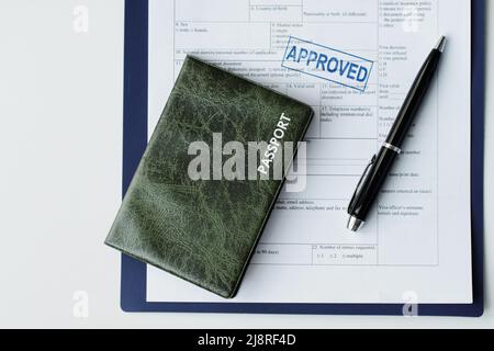 Revêtement plat de passeport en cuir vert foncé, papier de demande de visa de voyage avec sceau approuvé et stylo sur table, espace de copie Banque D'Images