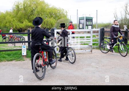 Des garçons juifs orthodoxes en vélo sur une piste cyclable traversant la porte de la réserve naturelle Walthamstow Wetlands à Londres, Angleterre KATHY DEWITT Banque D'Images