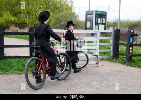 Des garçons juifs orthodoxes en vélo sur une piste cyclable traversant la porte de la réserve naturelle Walthamstow Wetlands à Londres, Angleterre KATHY DEWITT Banque D'Images