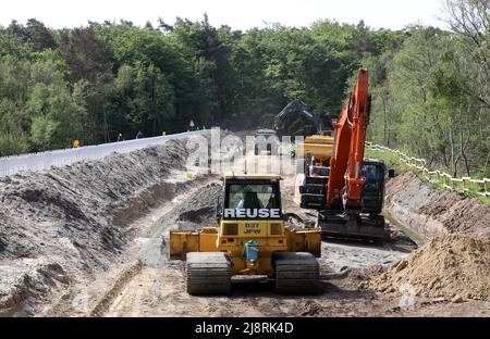 Ahrenshoop, Allemagne. 18th mai 2022. Sur la digue au nord-est d'Ahrenshoop, des véhicules de construction lourds élargissent la structure de protection côtière sur la mer Baltique. L'élargissement est nécessaire pour que la dune n'ait pas à être renforcée encore et encore après les ondes de tempête. L'élargissement de la section de 1,8 kilomètres de long au milieu du parc national 'Vorpommersche Boddenlandschaft' coûtera 3,9 millions d'euros. Credit: Bernd Wüstneck/dpa/Alay Live News Banque D'Images